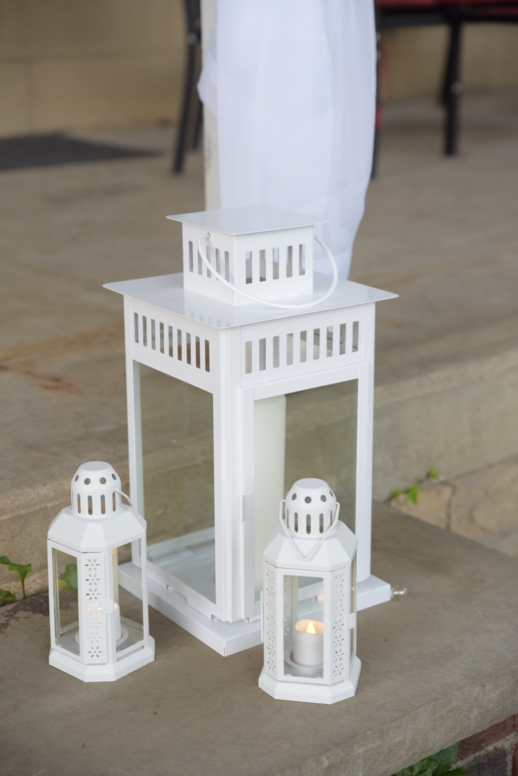 Three white candle lanterns decorating the wedding venue